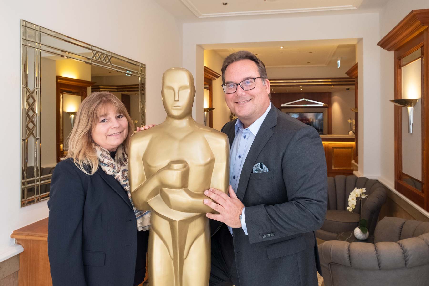 Hansa Hotel-Direktorin Ingrid Priem-Heinrich und Investor Michael Schramm mit "Oscar" in der Lobby des Hansa Hotels